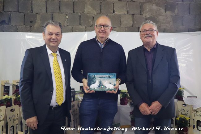 50. Neuseeländer-Club-Vergleichsschau 2024 in Stadtroda, Heinrich-Hartjes-Gedächtnispreis für Andreas Beckmann (Mitte) mit ZDRK-Präsident Bernd Graf (l.) und Ausstellungsleiter Herbert Sillmann.